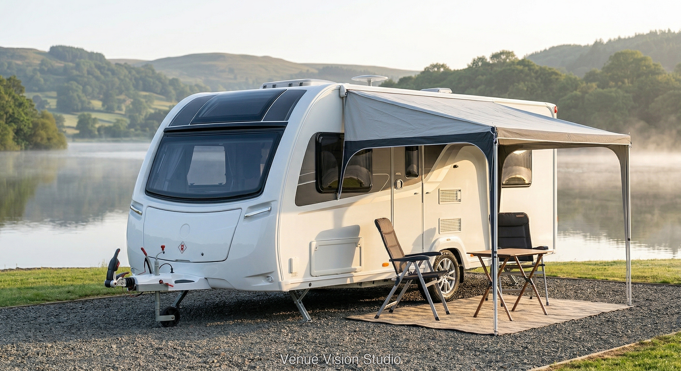 Caravan beside a lake with awning and camp chairs